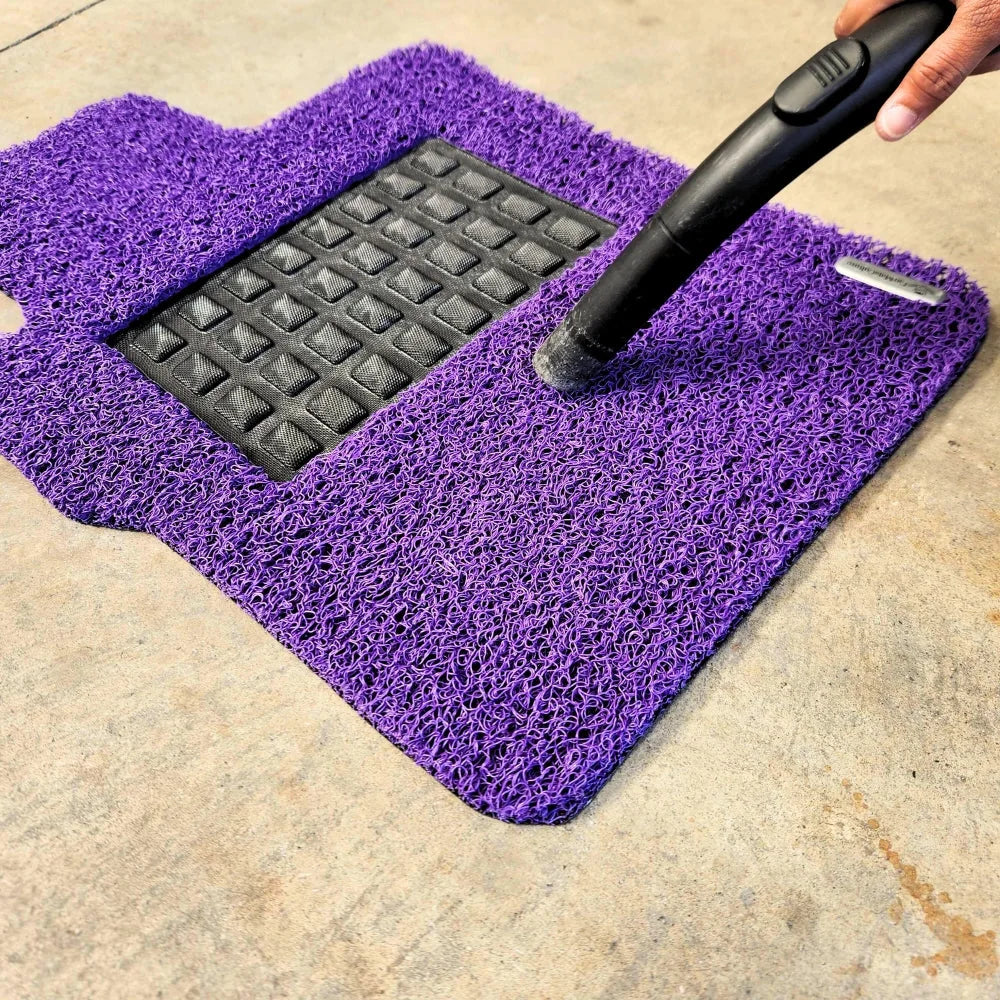 Vacuuming loose debris from a Sangria Purple CarMatsCulture mat