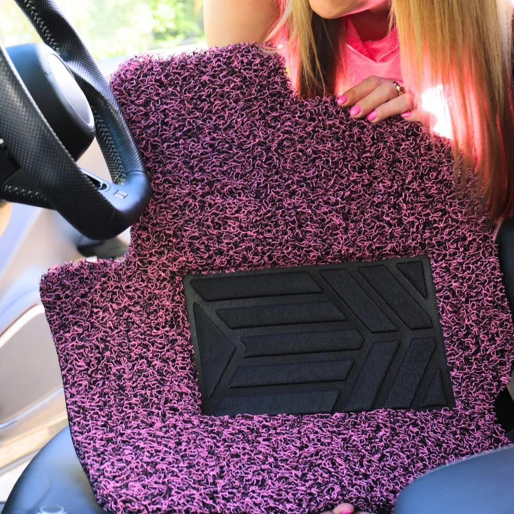 Customer holding a Taffy Pink car mat inside a vehicle